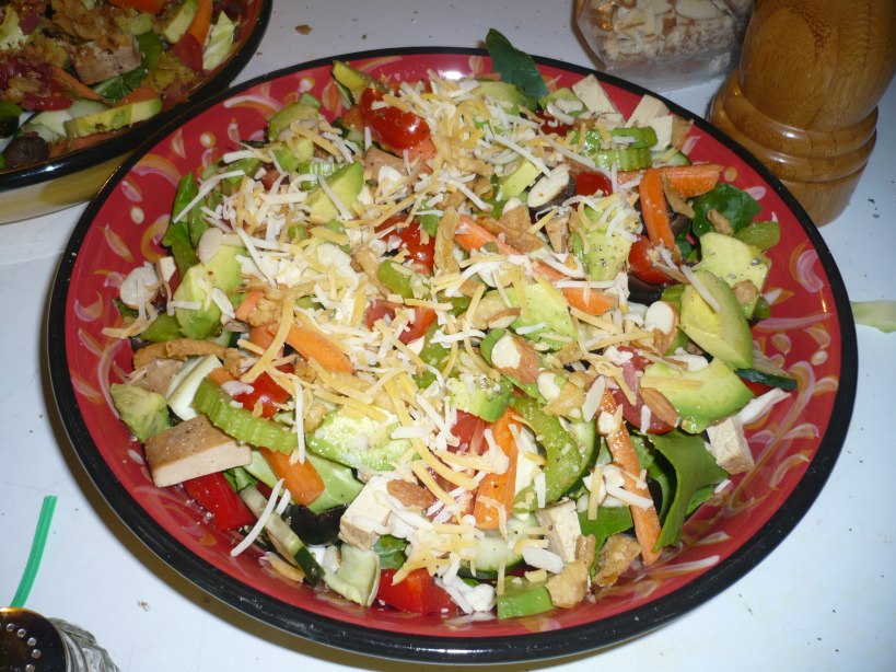 Salad including tofu, slided almonds, avocado, cheese, and more
