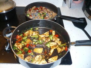 Two pans of Pad Gra Prao - tofu version in front, chicken version in back
